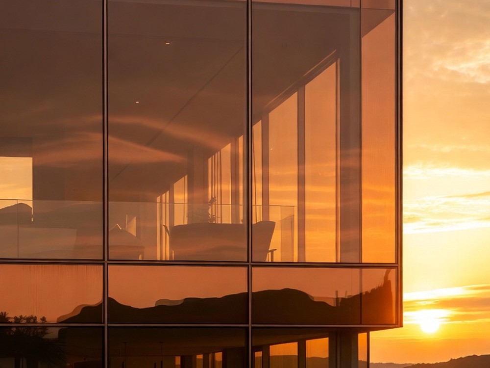Fachada acristalada de edificio de oficinas al atardecer